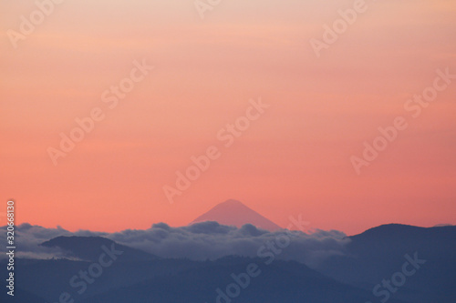 Silhouettes of mountains with clouds and volcano in the background - A view of the volcanoes of Guatemala - Sunset between mountains