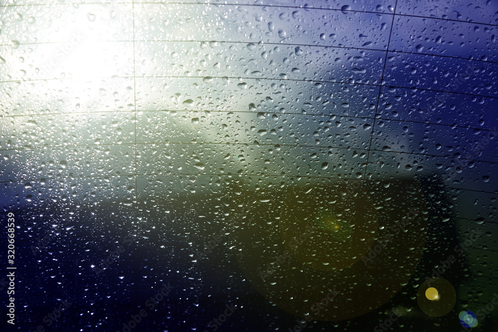 Krople deszczu na tylnej szybie samochodu z chmurami w tle. - obrazy, fototapety, plakaty 