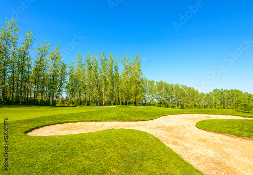 Golf course with yellow sand bunker and fantastic forest view.