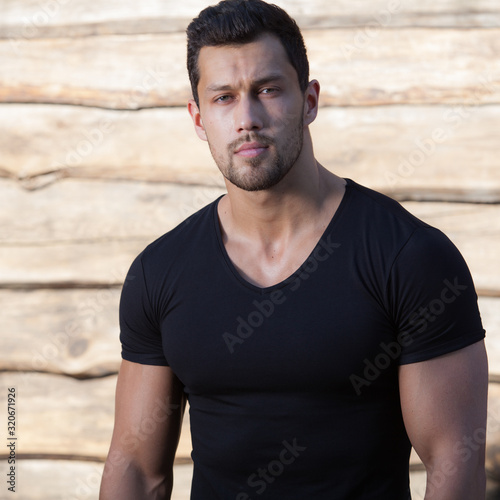 Portrait of handsome young man on wooden background.