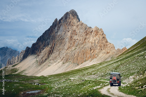 Off road caravain driving on a narrow path near the Rocca La Meja, famous mountain peak in che Alps of Piedmont, italy