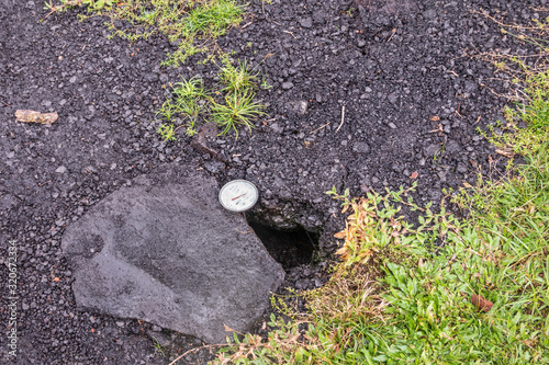 Leilani Estate, Hawaii, USA. - January 14, 2020: Devastation in parts untouched by 2018 lava. Dial placed in crack of road to measure temperature. Placed by government security forces.