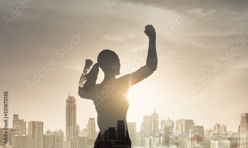 Strong confident young female in the city flexing her arms. People victory, confidence and achieving goals concept.  photo
