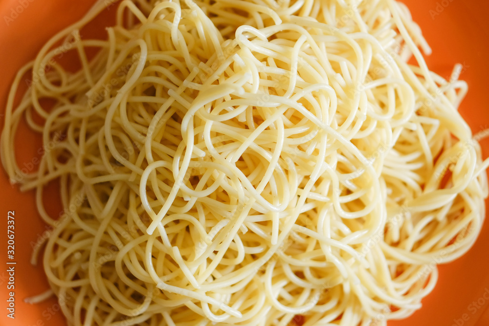 A lot of spaghetti on orange background