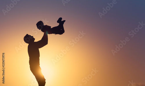 Happy father and son playing together in the park. Fatherhood and parenting concept. 