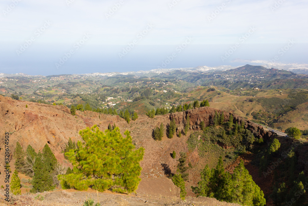 Scenic natural landscape with arid valley, vegetation and sea on background in Gran Canaria, Spain. Diversity nature formation on sunny day in Canary Islands