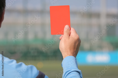 Football referee shows a red card. Disqualification.