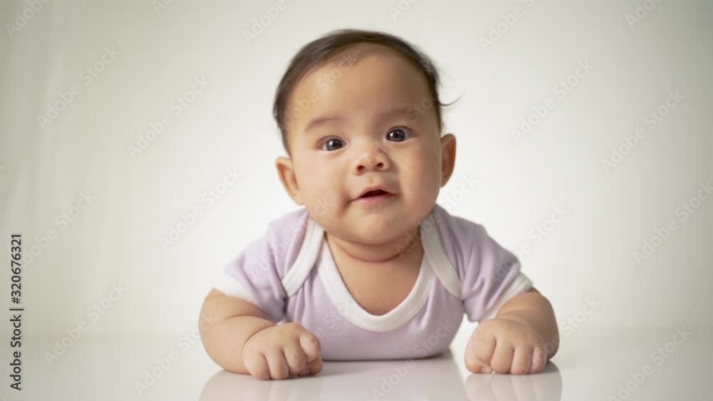 baby laying on her belly. tummy time cute baby in studio portrait baby laying on her belly. tummy time cute baby in studio portrait