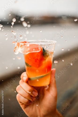 Eiswüfel fällt in einen fruchtigen Cokctail und lässt das wasser spritzen