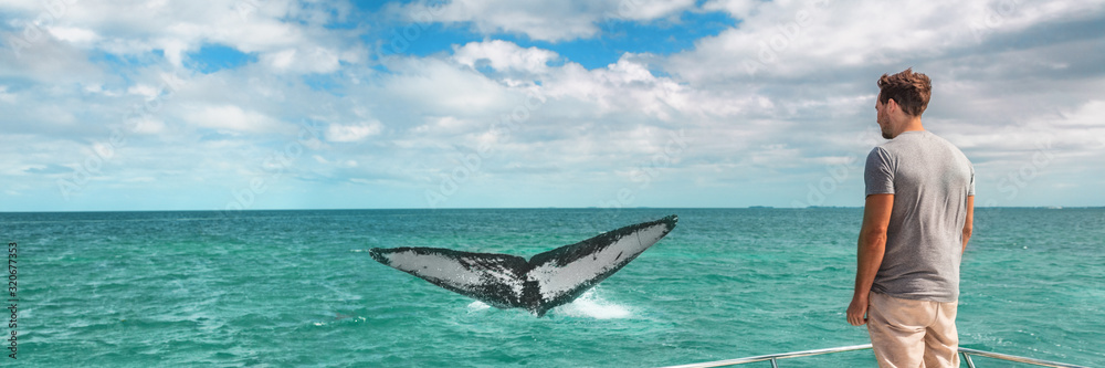 Fototapeta premium Whale watching boat tour tourist man panoramic banner background of humpback breaching flapping tail travel destination, summer vacation on deck of cruise ship.