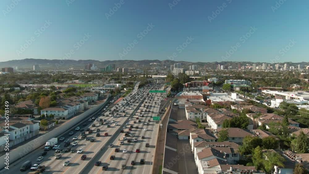 Aerial view of road signs, freeway and interstate traffic at I-405 and I-10 intersection in urban West Los Angeles with cars below on a sunny day. Aerial view of road signs, freeway and interstate traffic at I-405 and I-10 intersection in urban West Los Angeles with cars below on a sunny day.