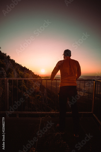 Man on top of mountain watching the sunrise . Conceptual scene.