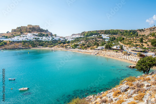 Lindos beach and white houses of village of Lindos and Acropolis in background (Rhodes, Greece)