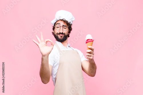 Fotografie, Obraz young crazy chef man with an ice cream against pink wall