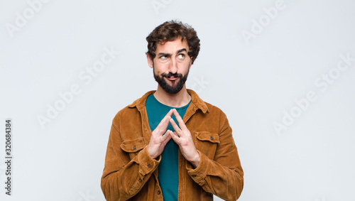 Slika na platnu young handsome man scheming and conspiring, thinking devious tricks and cheats,