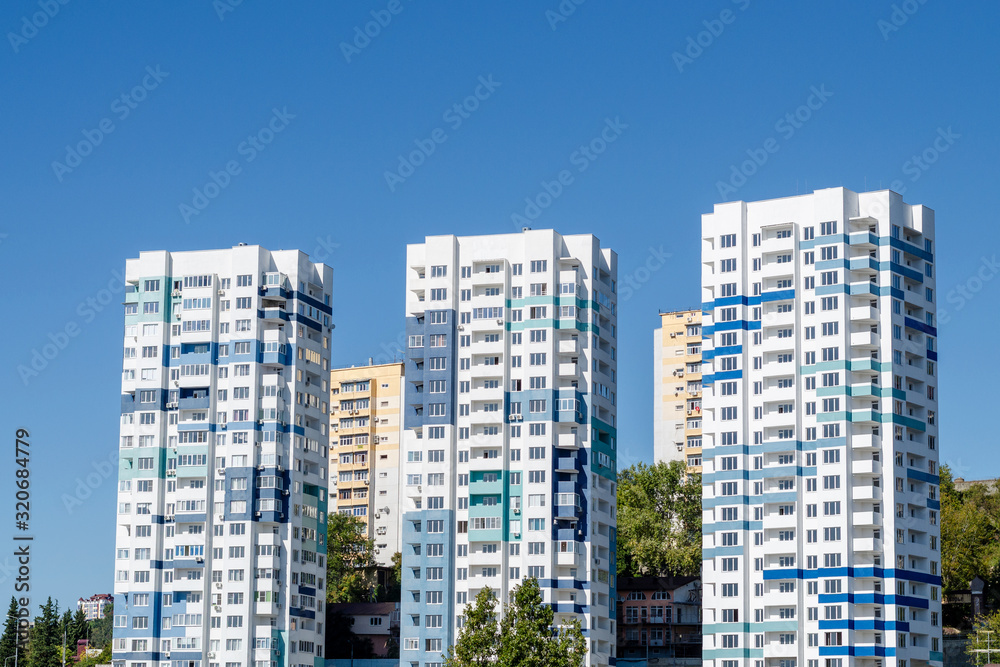 Three tall light blue modern apartment buildings. Close-up