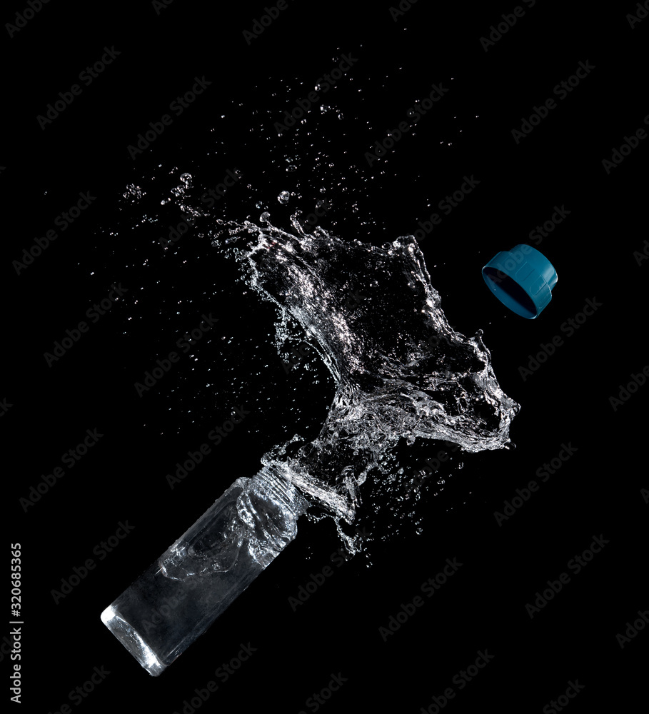 Bottle of drinking water splashing out isolated on black Bottle of drinking water splashing out isolated on black