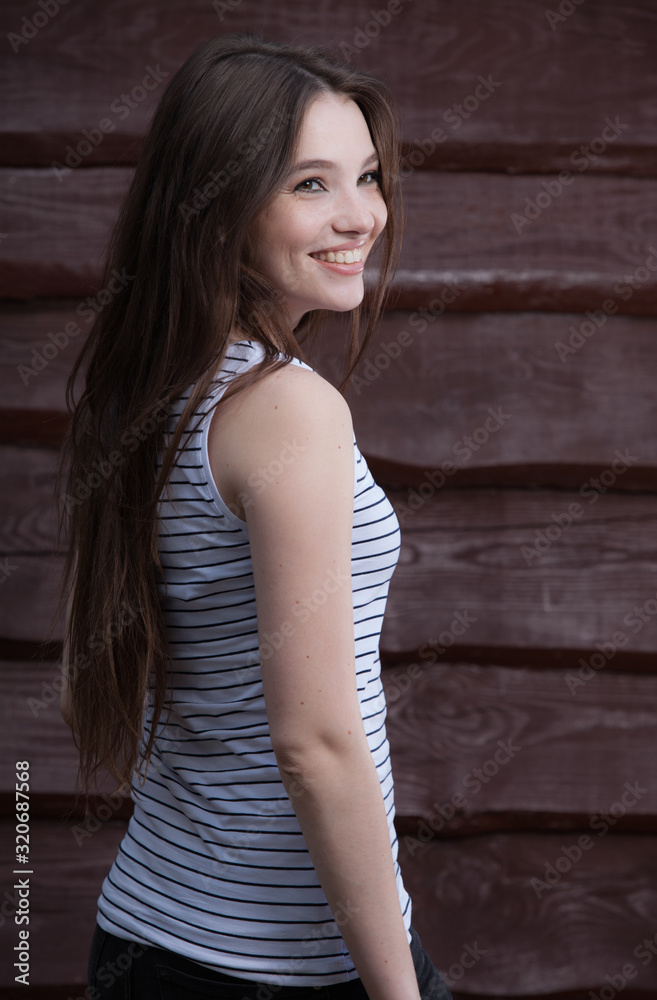 Fototapeta premium Portrait of beautiful young girl on wooden background.