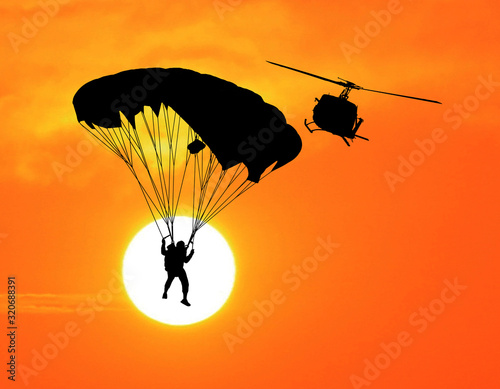  silhouettes parachuting on sunset
