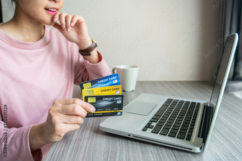 Woman holding credit card during using laptop for online shopping. Online shopping is the process of buying goods and services from merchants over the Internet. Woman holding credit card during using laptop for online shopping. Online shopping is the process of buying goods and services from merchants over the Internet.
