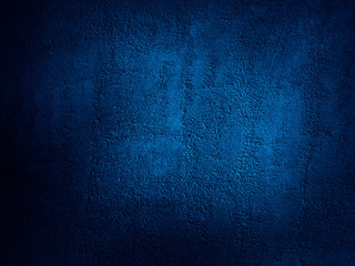 Abstract blue background. Dark blue grunge background. Rough grainy concrete wall surface texture. Deep blue concrete backdrop.