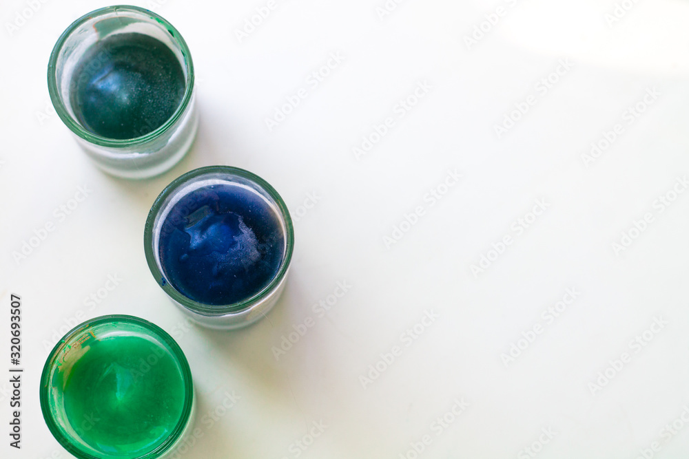 Glasses with frozen colored water on a white background. Background with place for text. Glasses with frozen colored water on a white background. Background with place for text.