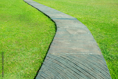 Concrete pathway in the park with lawn.