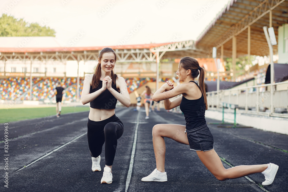 Beautiful girls at the stadium. Sports girl in a sportswear. Frends training