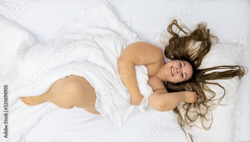 Fat plump woman with long hair, beaming with joy, view from above, copy space photo