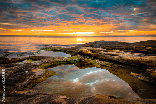 Picturesque sunrise over a rocky beach.