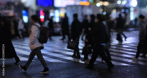 Walking people at the crossing in Shinjuku Tokyo rainy day at night photo