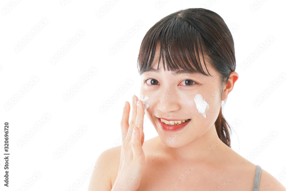 顔にクリームを塗る若い女性 顔にクリームを塗る若い女性