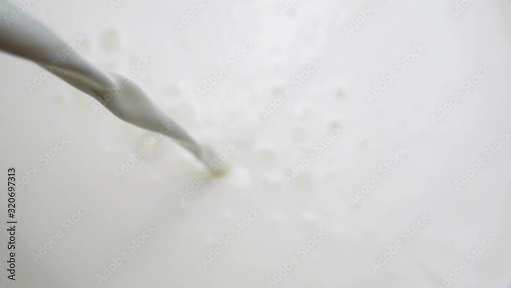 Pouring fresh milk in slow motion, moving water in a pot to use food ingredients, Closeup Front view Food concept.
