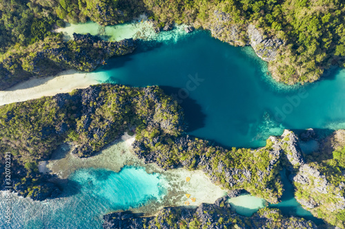 View from above, aerial view of the Big Lagoon and the Small Lagoon, two beautiful bays of crystal clear water surrounded by rocky cliffs. Miniloc Island, Bacuit Bay, El Nido, Palawan, Philippines.