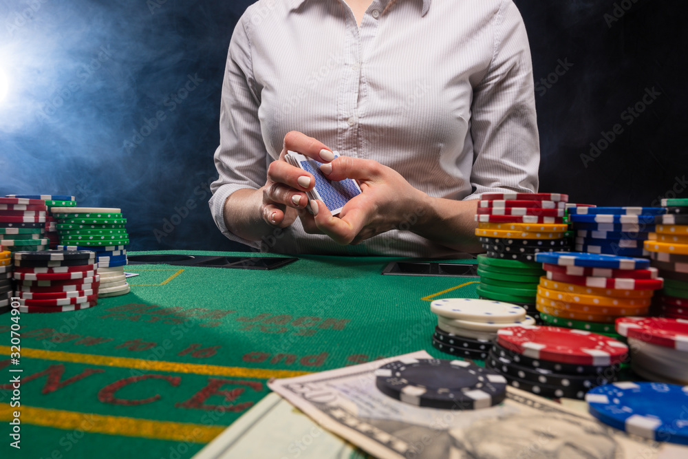 Girl dealer, in the casino gives out cards. A lot of chips, money. The concept of business, games and casinos. Girl dealer, in the casino gives out cards. A lot of chips, money. The concept of business, games and casinos.