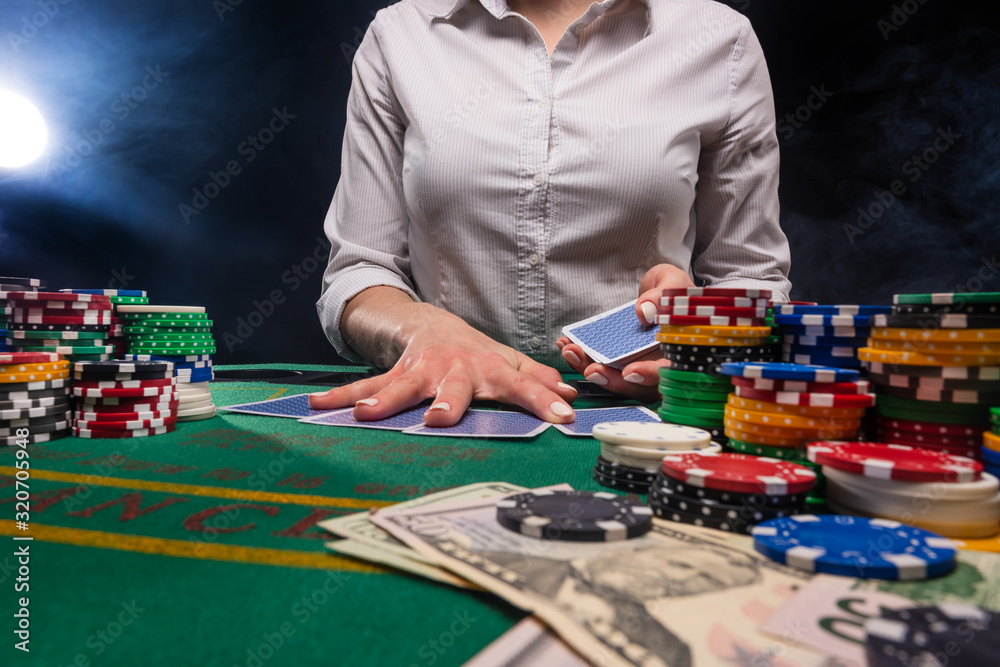 Gambling and gaming business in a casino. Girl hands out cards. Concept of playing cards.