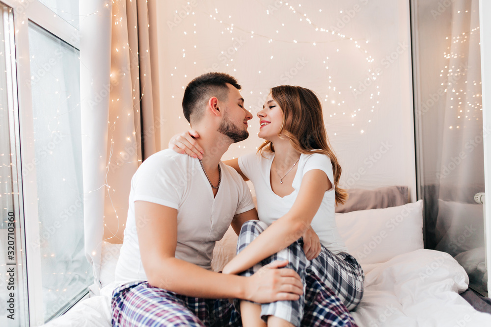 Stunning white woman looking at husband with love. Blissful female model expressing positive emotions in morning with boyfriend. Stunning white woman looking at husband with love. Blissful female model expressing positive emotions in morning with boyfriend.