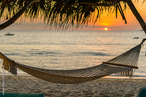 Fototapeta Naklejka Na Ścianę i Meble -  Empty hammock in the tropical beach in the Phuket at sunset,thailand.