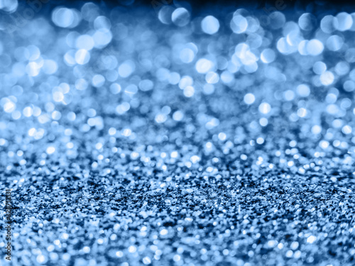 Blue sequin background. Blue sparkle background. Holiday abstract glitter background with blinking lights. 