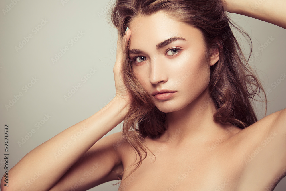 Naklejka premium Portrait of a beautiful girl with natural makeup. Beauty style shot. Clean skin and hair. Close up.