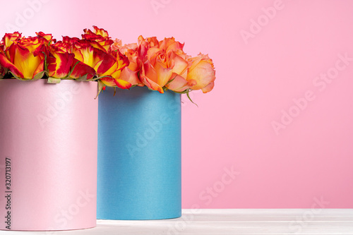 Cardboard box with roses on pink background