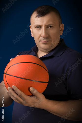The man the athlete with the basketball ball in hands. Studio shooting.