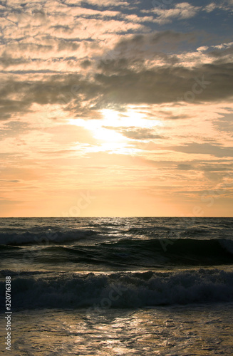 Beautiful sunset on tropical beach. The surf pounds the shore. Karon beach, Phuket, Thailand