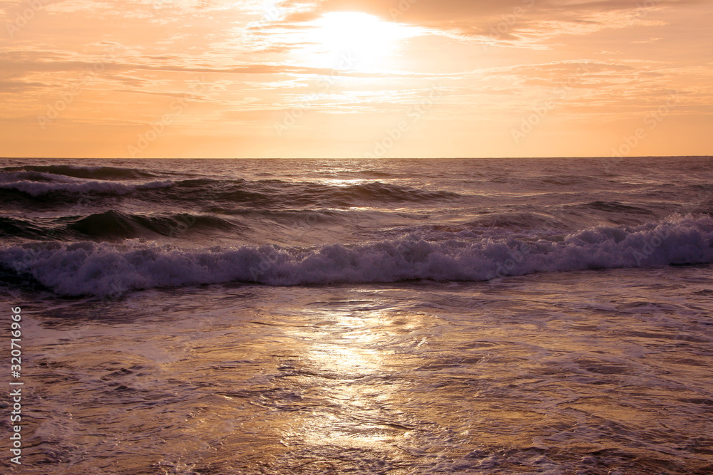 Beautiful sunset on tropical beach. The surf pounds the shore. Karon beach, Phuket, Thailand