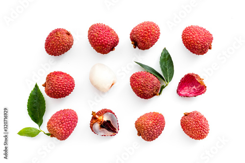 Lychee fruits pattern with leaves on white background flat lay top-down