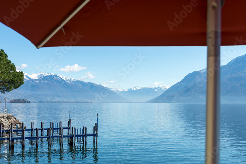 Alpine Lake with Snow-capped Mountain Under a Parasol in Ticino, Switzerland. © Mats Silvan