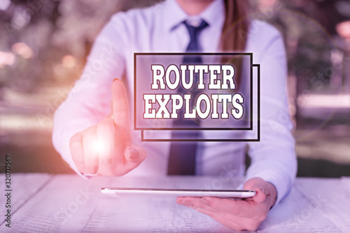 Conceptual hand writing showing Router Exploits. Concept meaning takes advantage of a security flaw in an application Female business person sitting by table and holding mobile phone photo