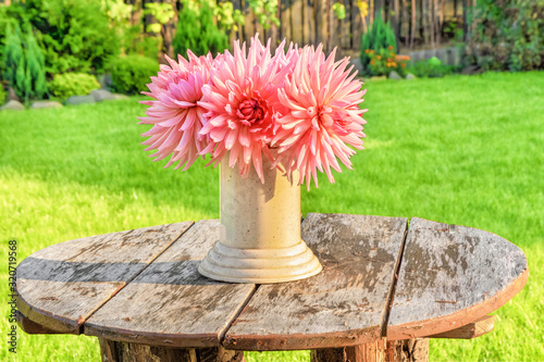 A bouquet of Dahlia flowers on an old wooden table in the yard of the house