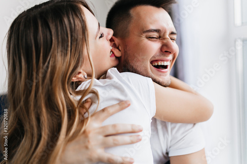 Dark-haired enthusiastic woman fooling around with husband. Funny lady enjoying weekend with boyfriend.