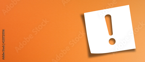 Note paper with exclamation mark on panoramic orange background